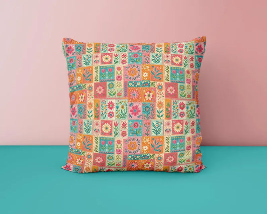 A square throw pillow with a colorful patchwork floral pattern, set against a split pink and teal background.